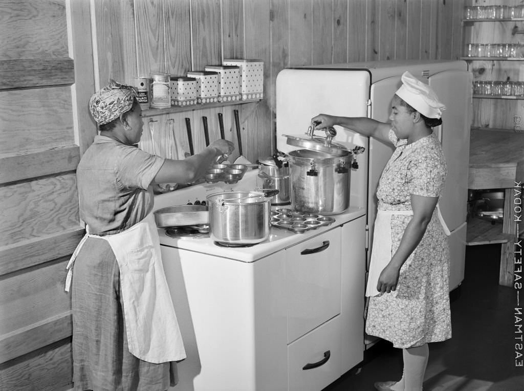 #205 Two Female Workers preparing Hot Lunch for Agricultural Workers’ Children in Kitchen of Day Nursery, Okeechobee Migratory Labor Camp, Belle Glade, Florida, February 1941