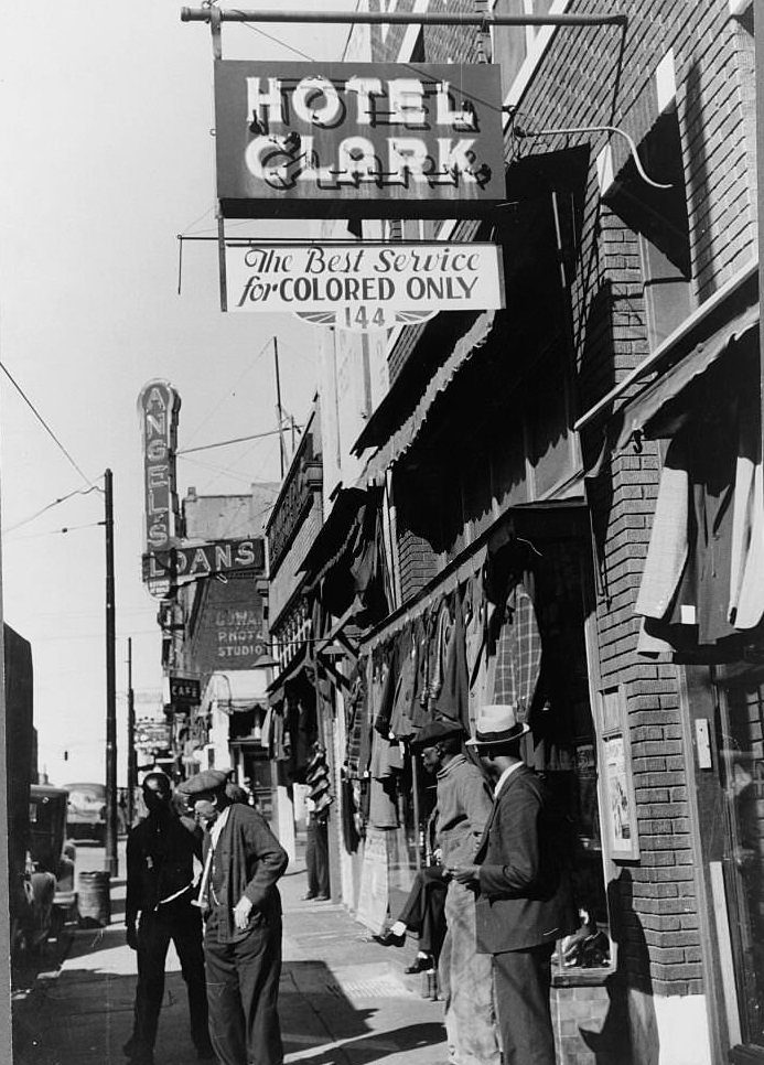 #55 Men on the sidewalk in front of a secondhand clothing store on Beale Street, Memphis, Tennessee, 1939.