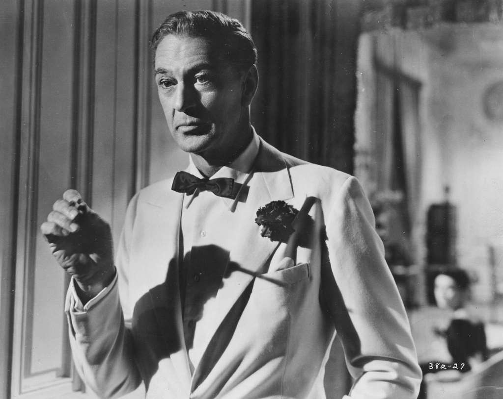 Gary Cooper, wearing a tuxedo and a button hole, and smoking a cigarette, in a scene from the movie ‘Love in the Afternoon’, 1957.