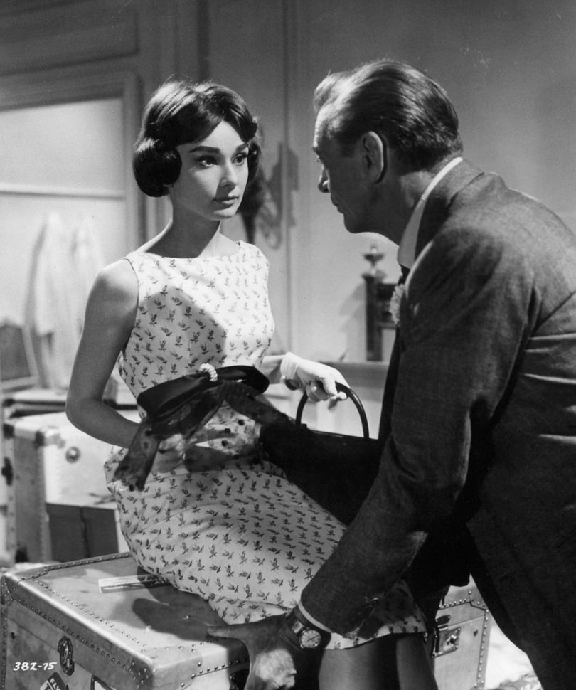 Audrey Hepburn sitting on trunk as Gary Cooper leans towards her in a scene from the film ‘Love In The Afternoon’, 1957.