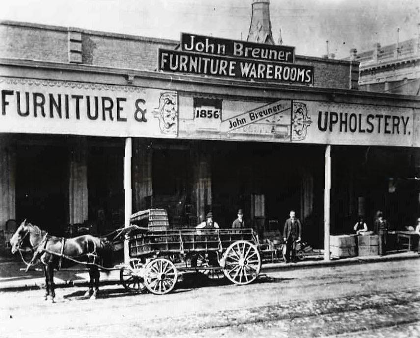 #7 Exterior view of John Breuner Furniture Warerooms showing the delivery wagon and six men posing next to the wagon in front of the store, 1856