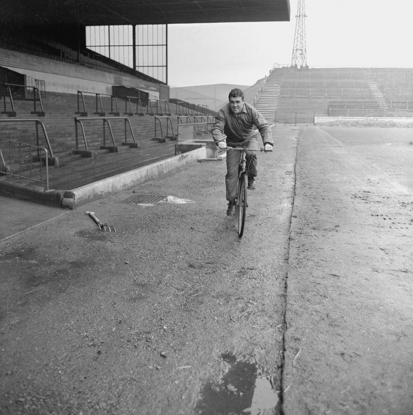 #124 Leeds United and Scotland international Bobby Collins in training on a bike at Elland Road, 1960