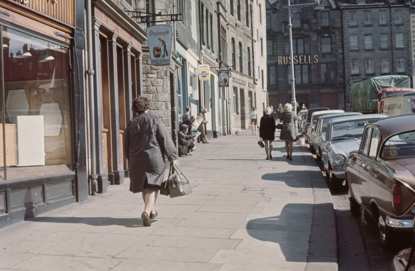 #19 Pedestrians walk up a city street in the Grassmarket area of the Old Town in Edinburgh, Scotland, 1965.