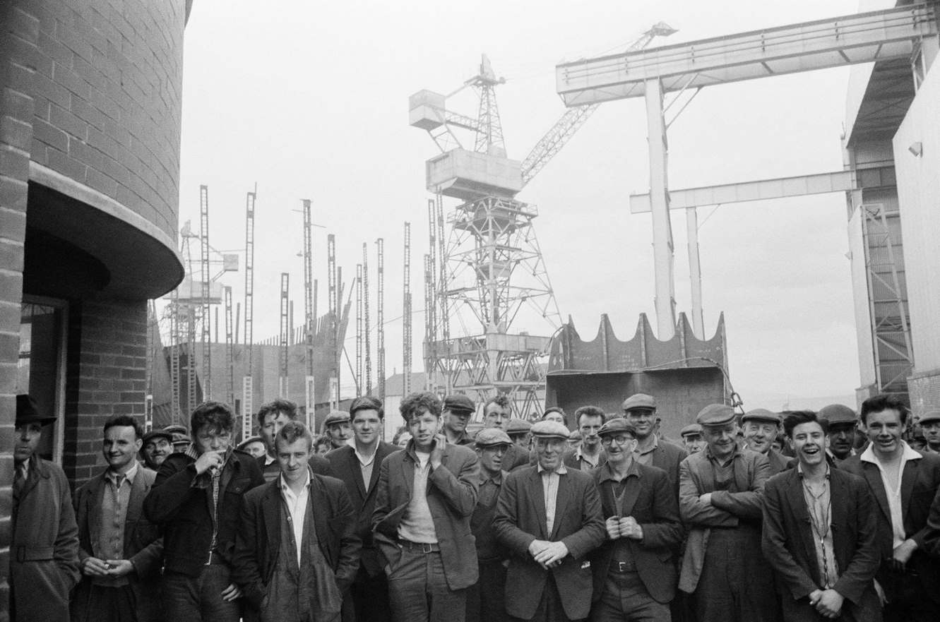 #39 Shipbuilders leaving a shipyard at Greenock on the Clyde, Scotland, 1963.