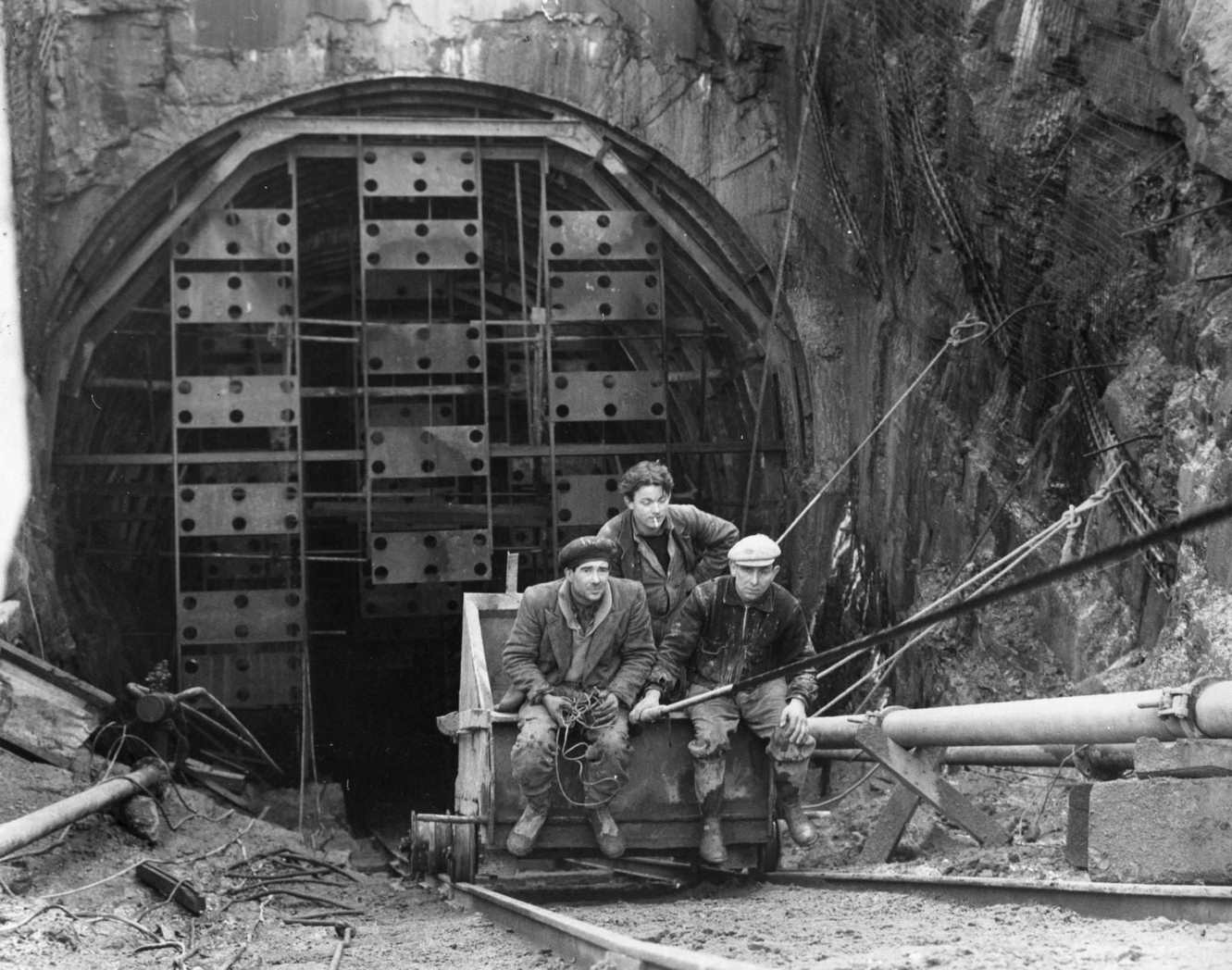 #81 Workers being hoisted up from one of four anchor tunnels to hold securing cables of the Forth Road Bridge, which crosses the river near Edinburgh, 1960