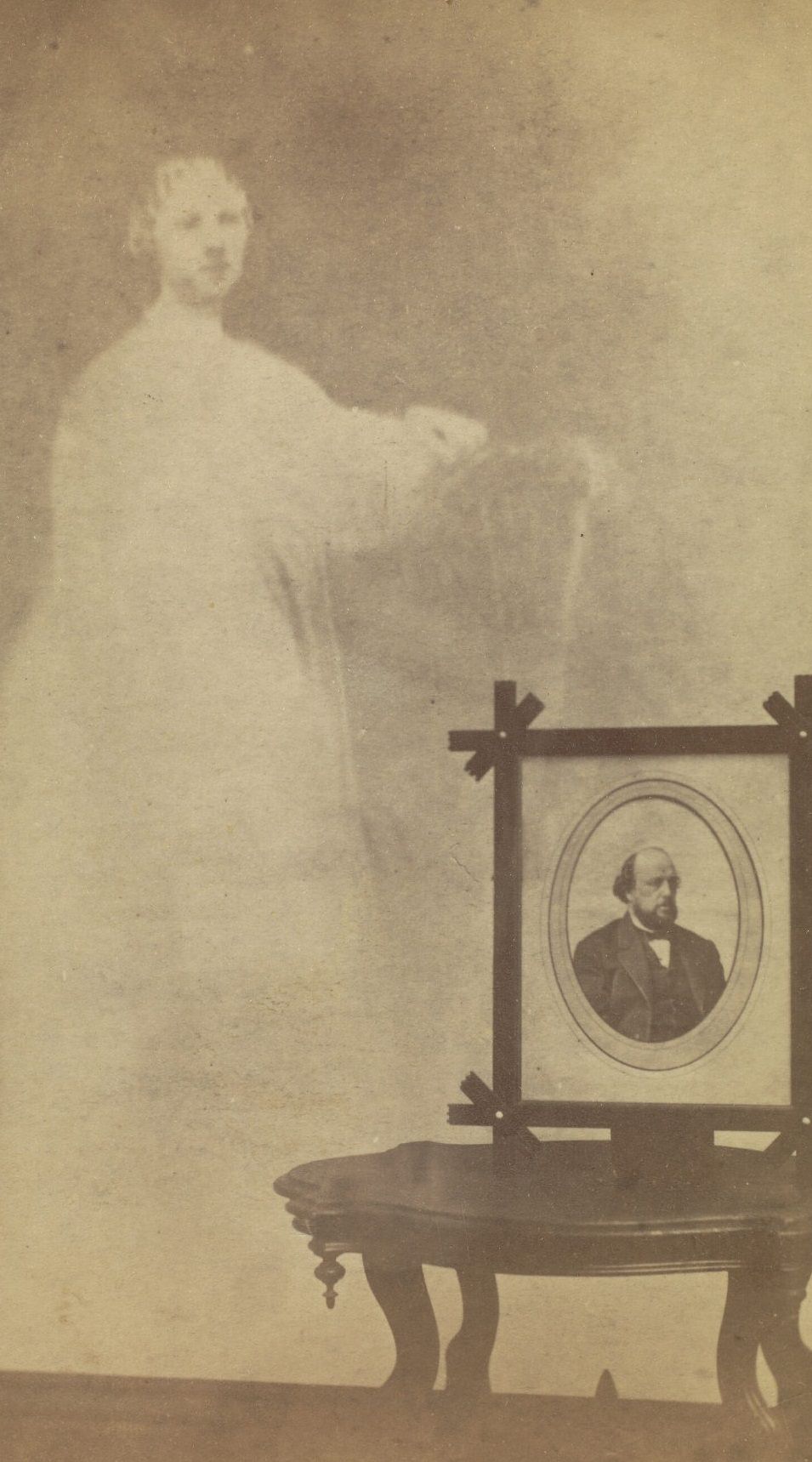 #28 A framed portrait of Mr. Brown perched on a side table, with the faint image of a woman next to it.