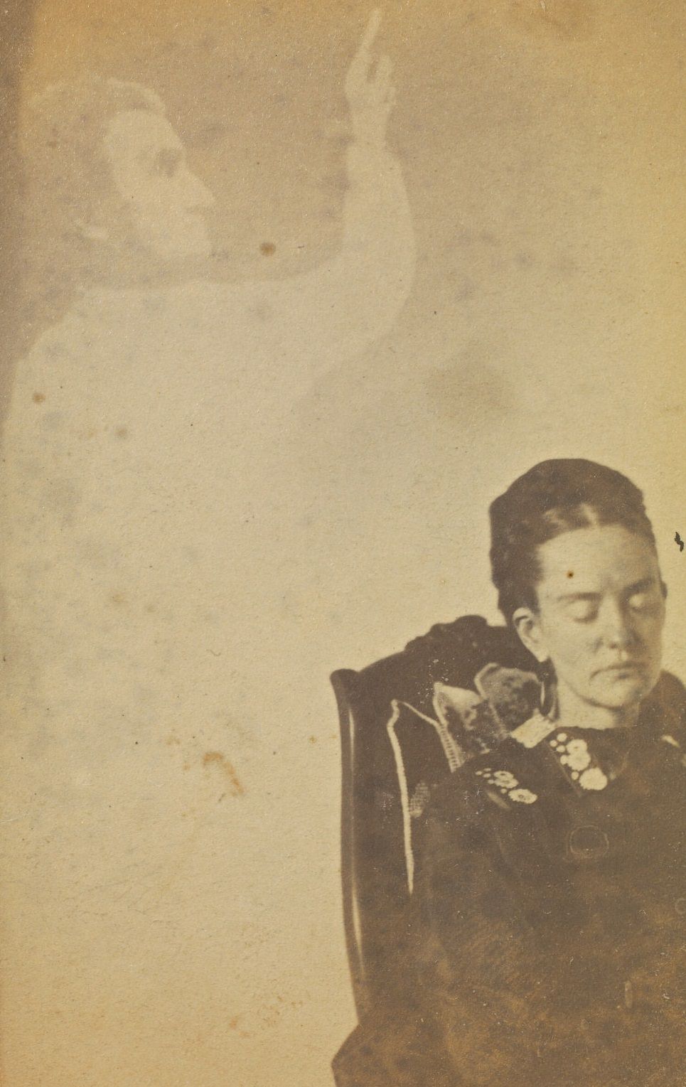 #3 Portrait of a woman sitting in a chair, wearing a dark dress and with her eyes downcase.