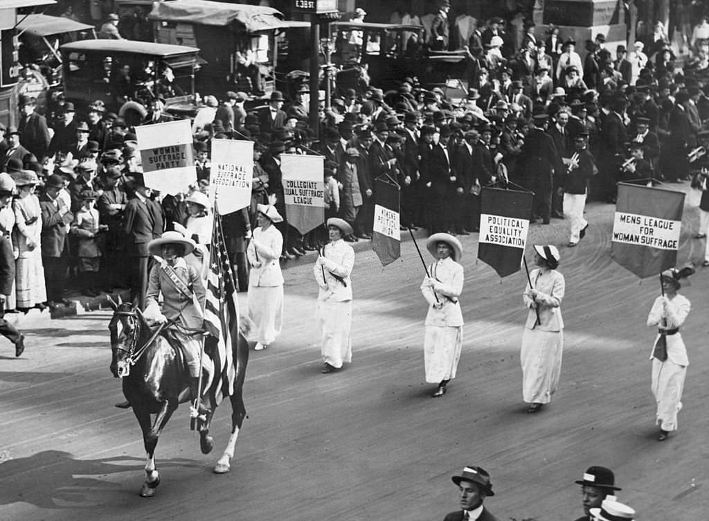 #10 Grand Marshal Inez Milholland Boissevain leads a parade of 30,000 representives of the various Women’s Suffrage associations, 1913
