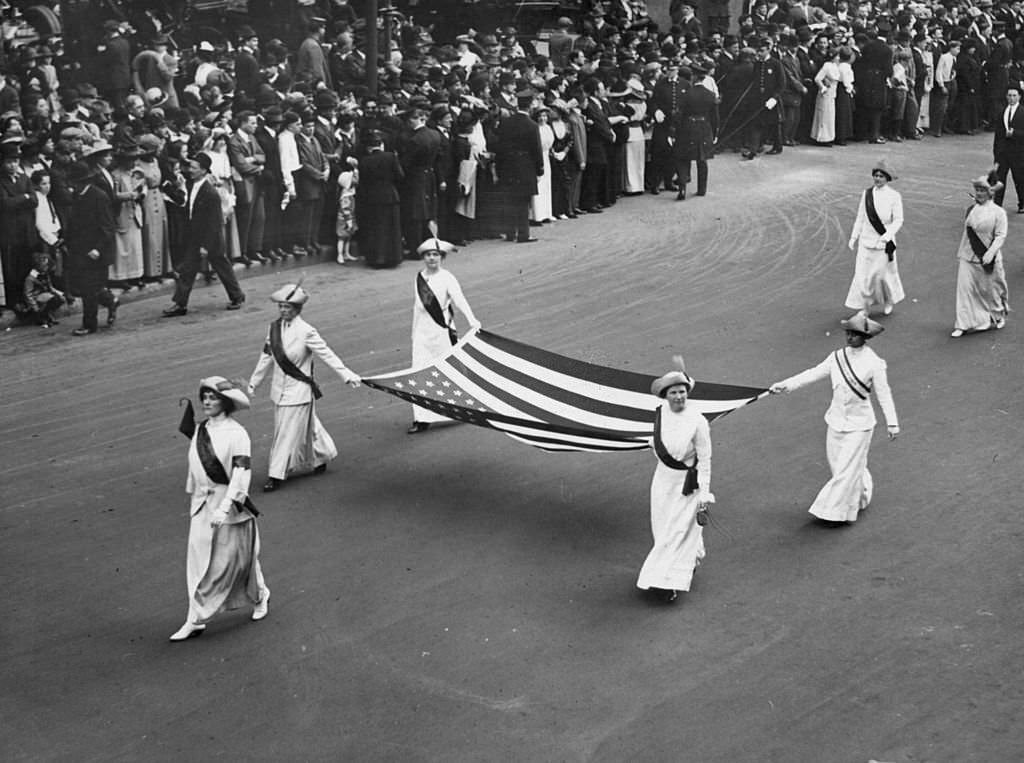 #12 A group of ladies carrying the American flag on a Women’s Suffrage Parade, 1913