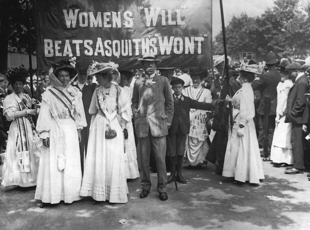 #39 Suffragettes dressed in their white uniforms carry a banner at the funeral of their fellow campaigner Emily Davison, who died making a protest at the 1913 Epsom Derby.