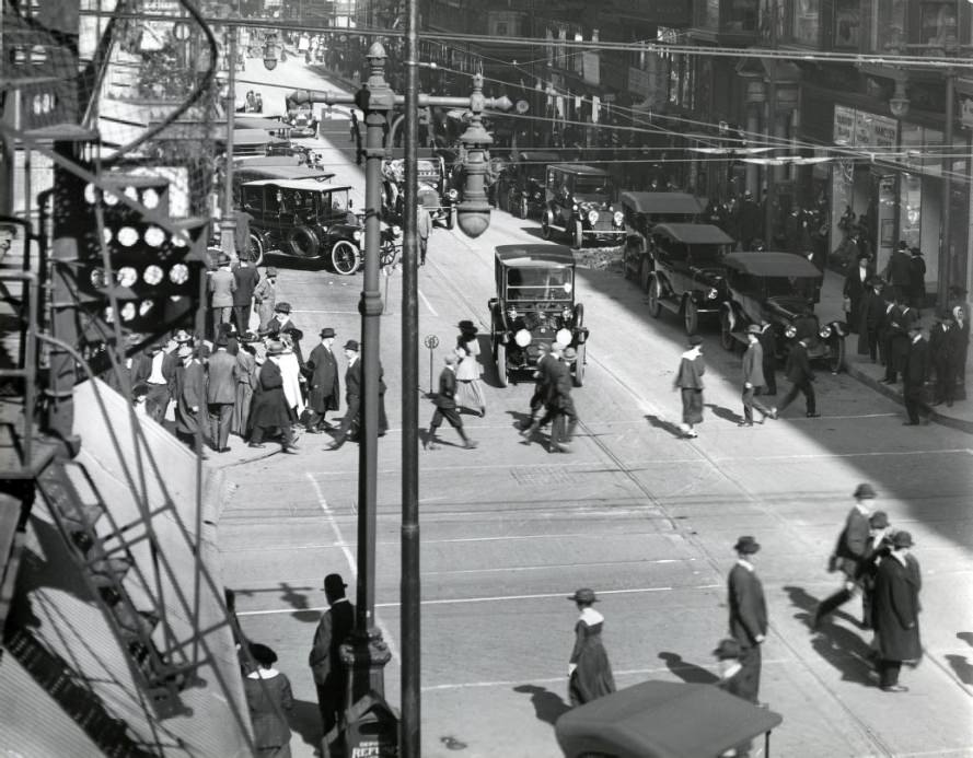 #122 Olive and 7th Street, looking east. Hanover and Regal shoes in the right foreground. Many pedestrians crossing the street, 1909