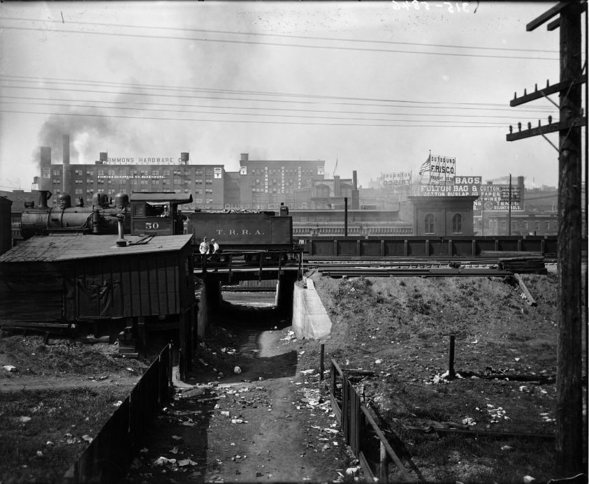 #129 Terminal Railroad Association train engine with tender stopped in rail yard, warehouses in the Cupples station block are visible in the background, 1909
