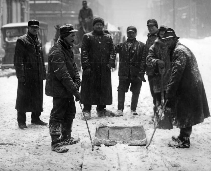 #141 Team of men working in the middle of a city street during a snowstorm, 1902