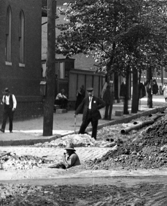 #144 Men installing a pipe in a city street, 1908