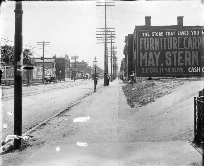 #102 Looking along city sidewalk with major street on one side and vacant lot on the other, 1906