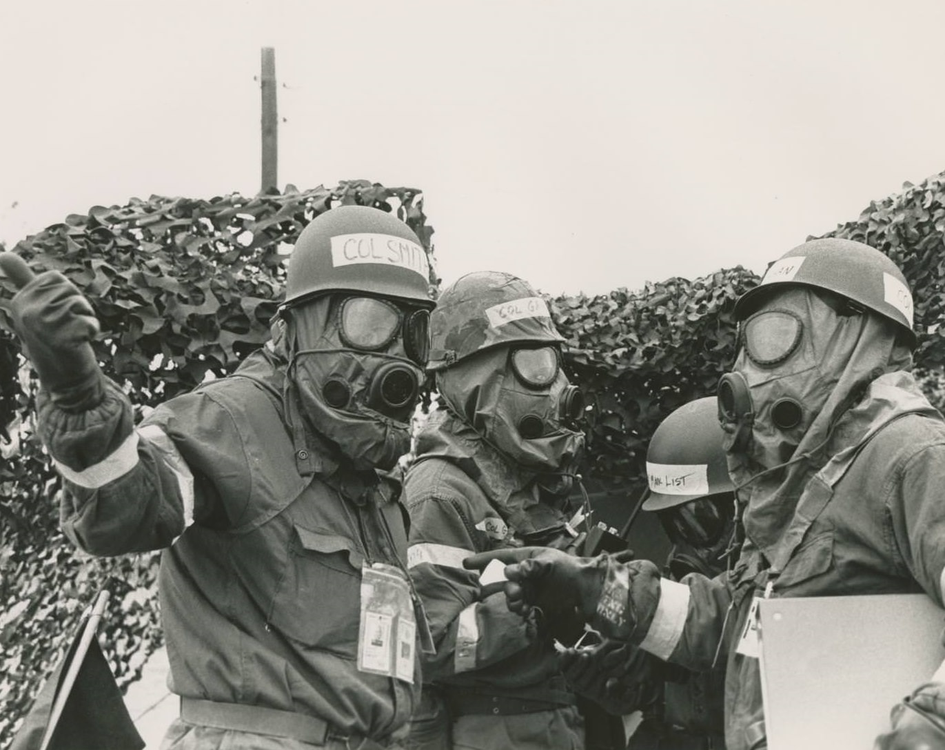 #23 Several officers in gas masks standing together during a mock casualties and chemical warfare exercise at the Bergstrom Air Force Base, 1973