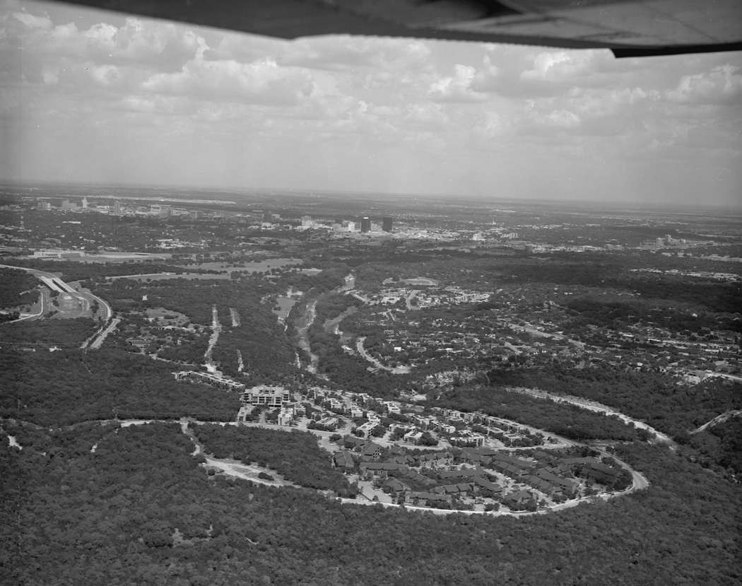 #3 The sky of downtown Austin and the new Austin high school building where the city can be seen in the distance, along with small neighborhoods and suburbs in the foreground, 1978