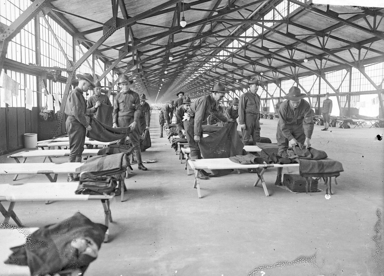 #125 US Army 3rd Reserve Engineers folding blankets at their cots set up in the building at the Municipal Pier (Navy Pier), Chicago, Illinois, 1910s.