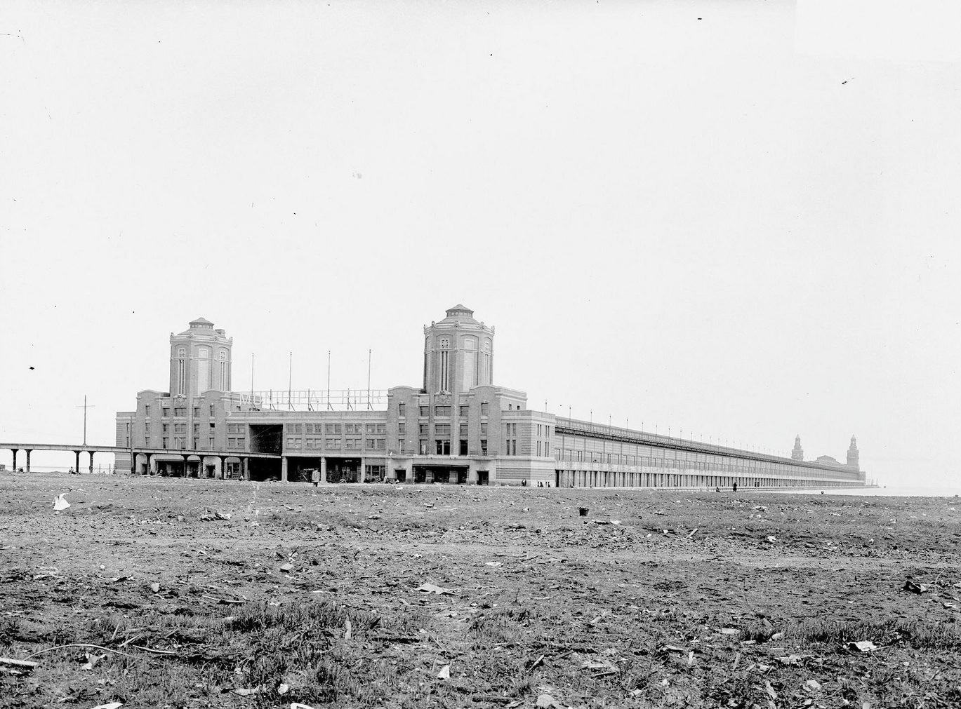 #126 Municipal Pier (now called Navy Pier) under construction, seen from across a dirt field in front of it, in the Near North Side community area, Chicago, Illinois, 1910s.