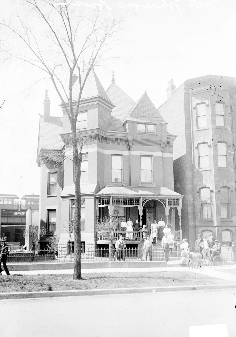 #141 The home of Jack Johnson in Chicago, IL, 1910. Many people are standing on the porch and in front of the building.