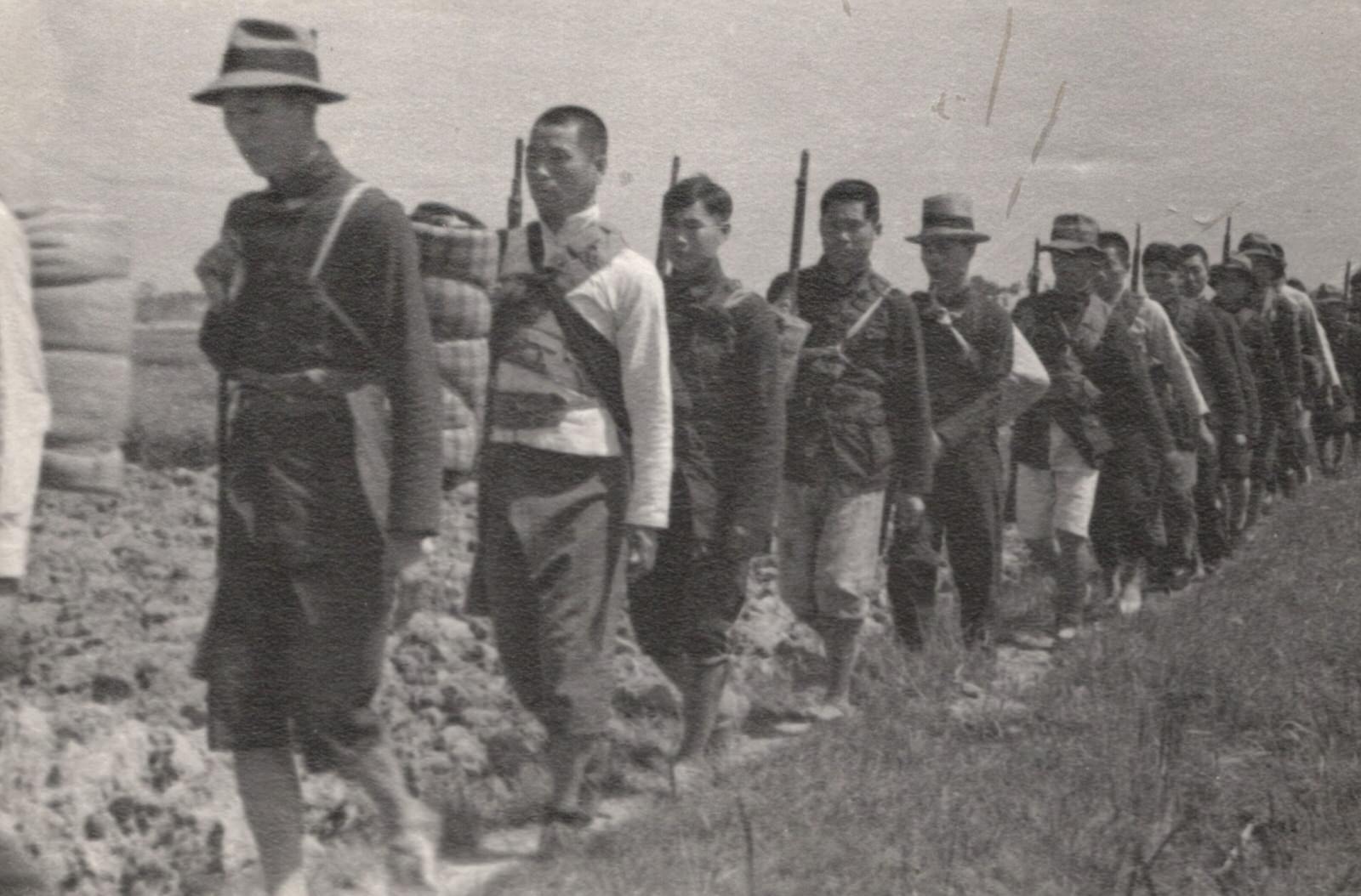 #100 Chinese guerrillas (farmers) who have arisen in the tracks of the Japanese, along the lower Yangtze (Yangzi) River Valley, to fight the invader. They were on their way to join the Communist guerrillas.