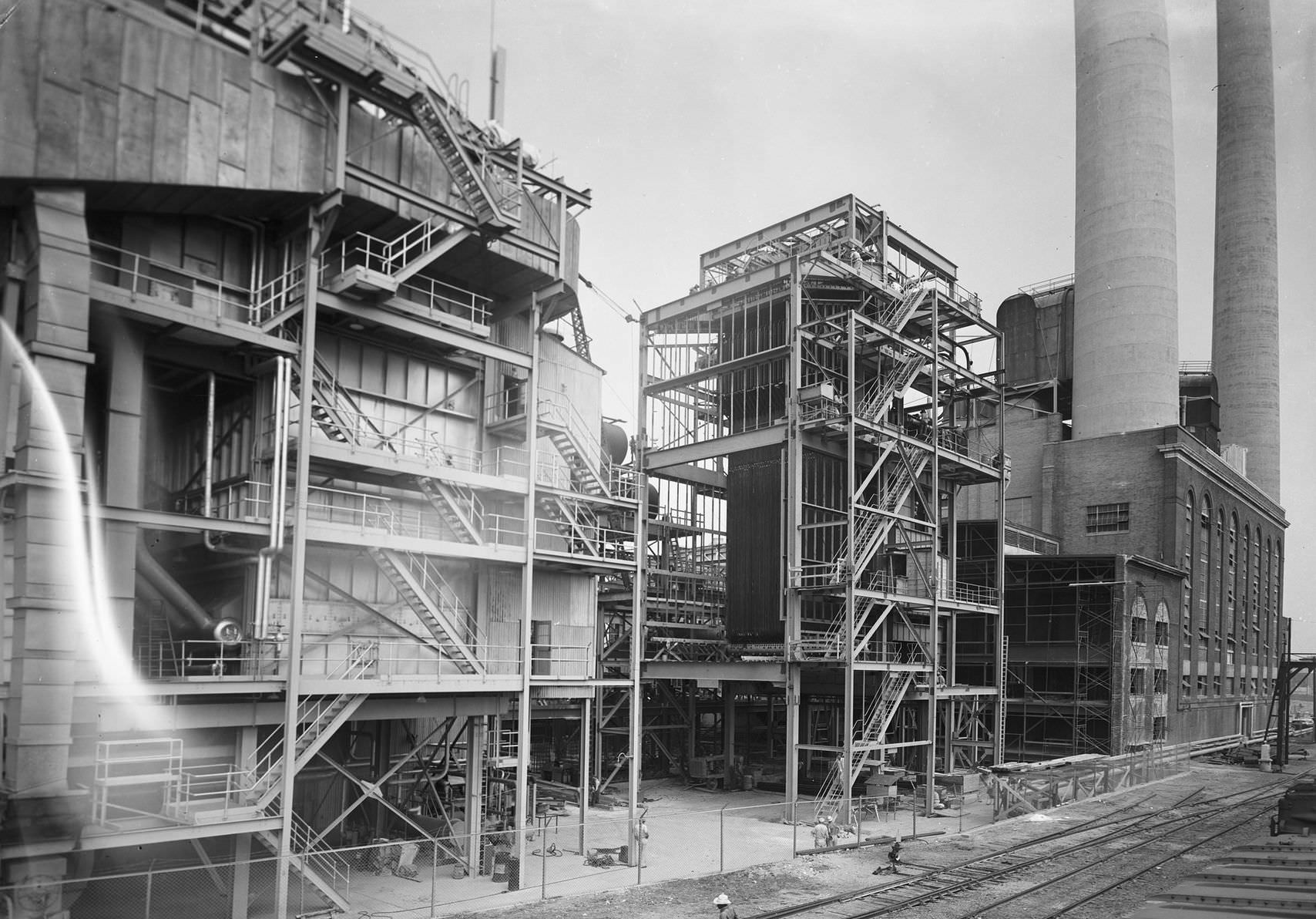 #135 Power plant, downtown Dallas, Texas, 1953. The picture shows a view from outside the power plant in downtown Dallas. There is a railroad next to the plant.