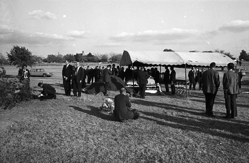 #125 Lee Harvey Oswald’s funeral at Rose Hill Cemetery with people (mostly reporters) standing near the gravesite, Fort Worth, Texas, 1963