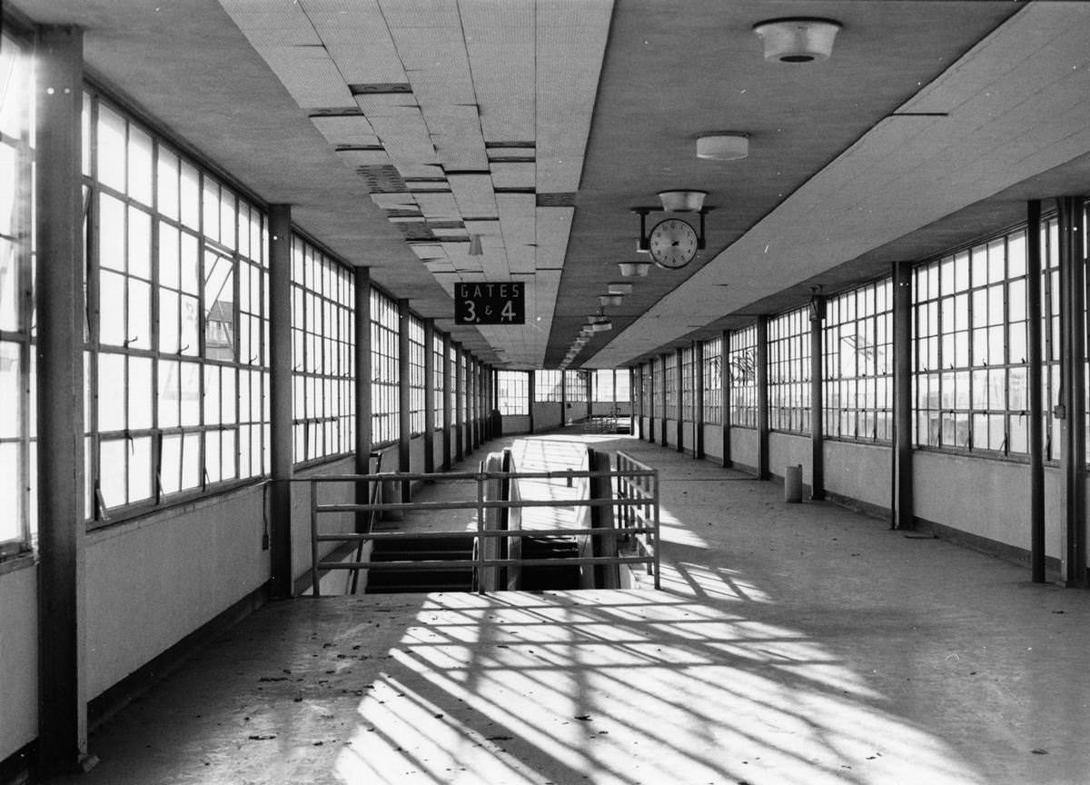 #71 Empty concourse, Gates 3 and 4, clock hanging from ceiling, Greater Southwest International Airport, 1968