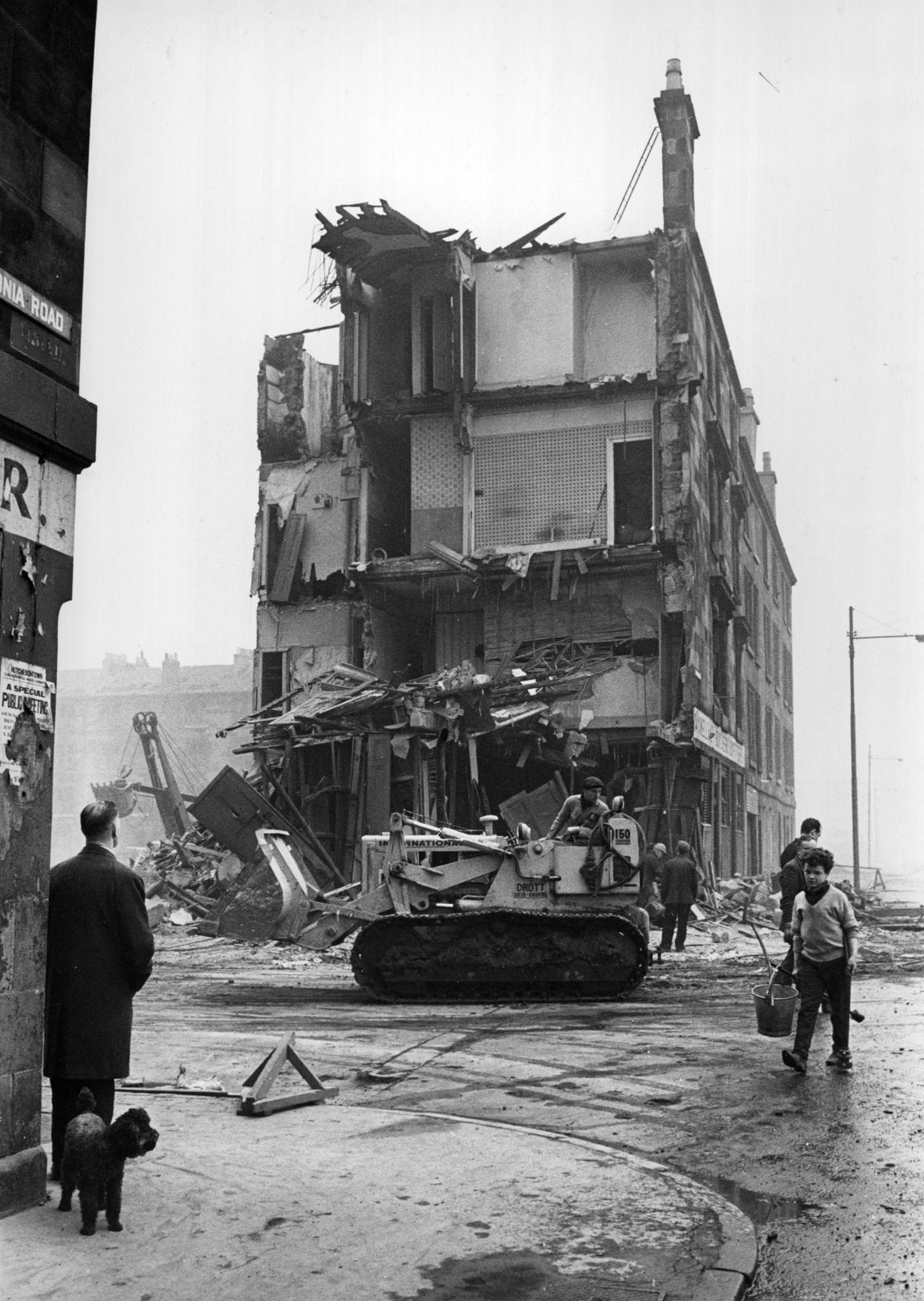 #1 A workman in a bulldozer in front of a tenement being demolished in the Gorbals area of Glasgow, 1960