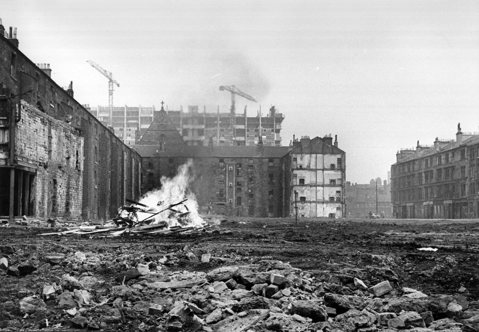 #15 An area of cleared ground in the Gorbals area of Glasgow where debris from the newly-demolished slum tenements is being burnt on a bonfire, 1960