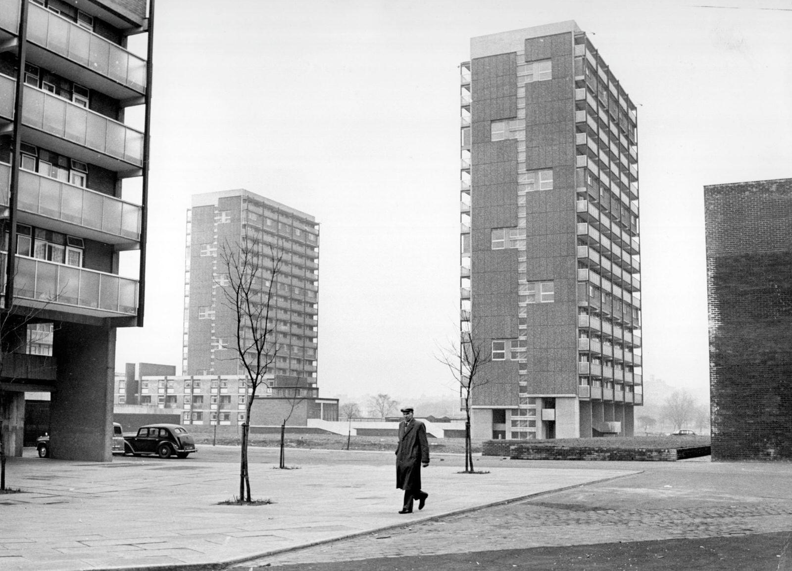 #17 A man walking past modern tower blocks in the Gorbals area of Glasgow, 1960