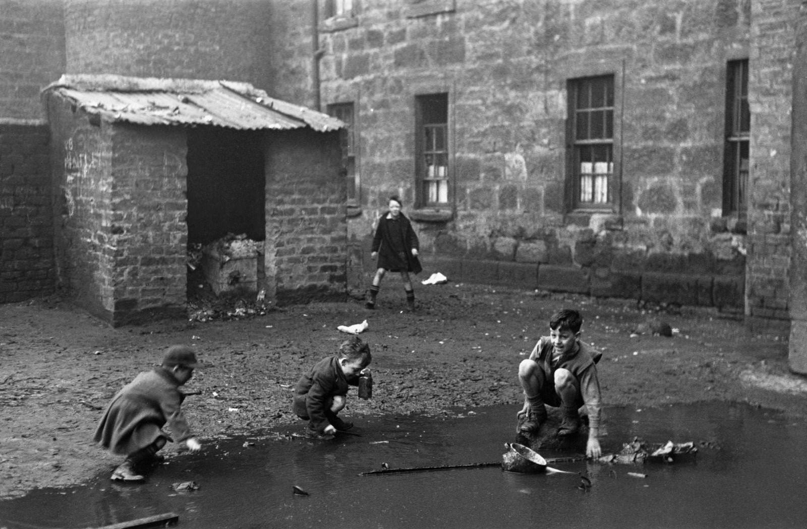 #46 Children play in a yard with the ‘Gorbals’, a notorious slum area of Glasgow, January 1948.