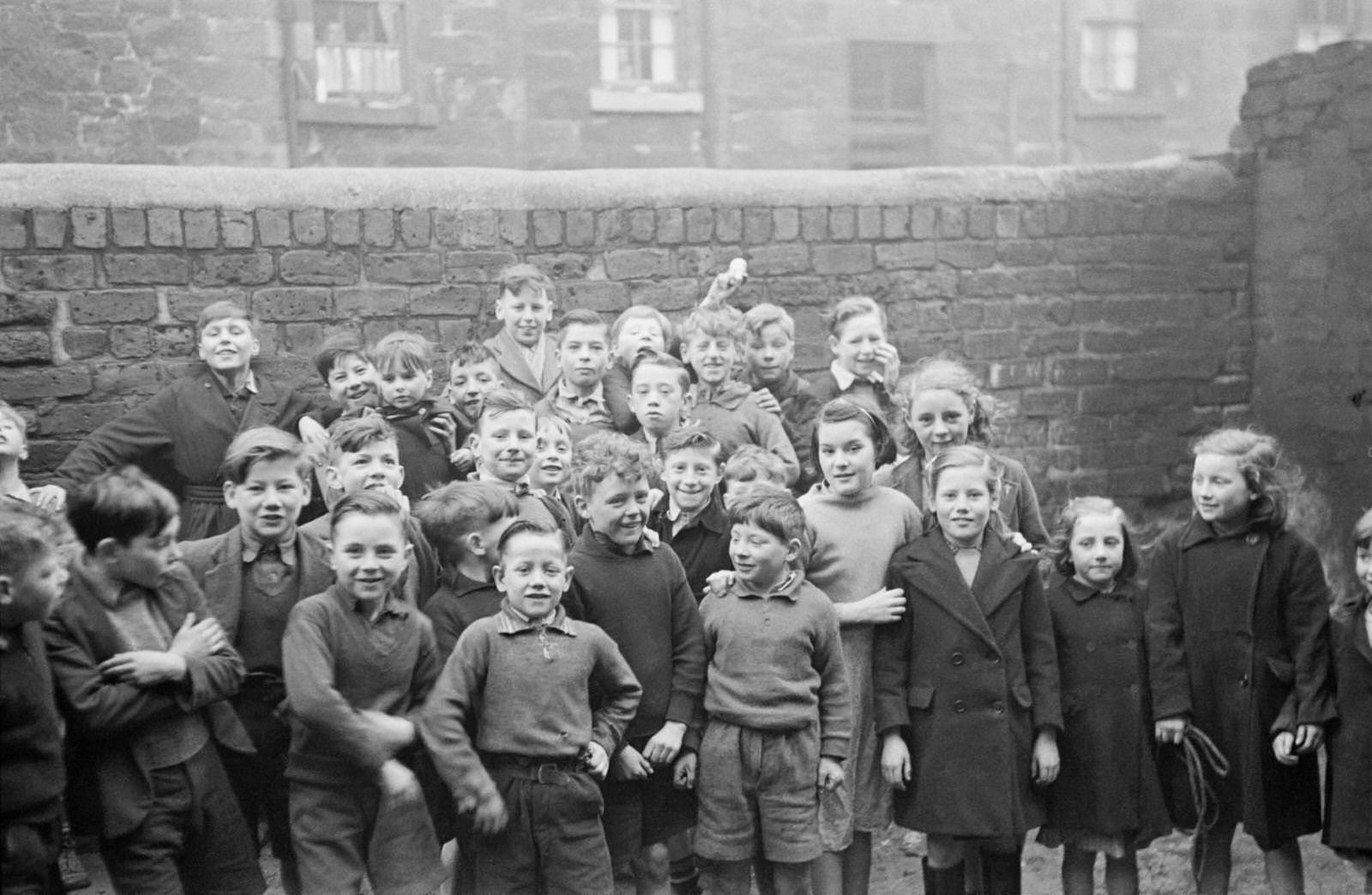 #48 Boys and girls pose for the camera in the Gorbals, a slum district of Glasgow, 1948.