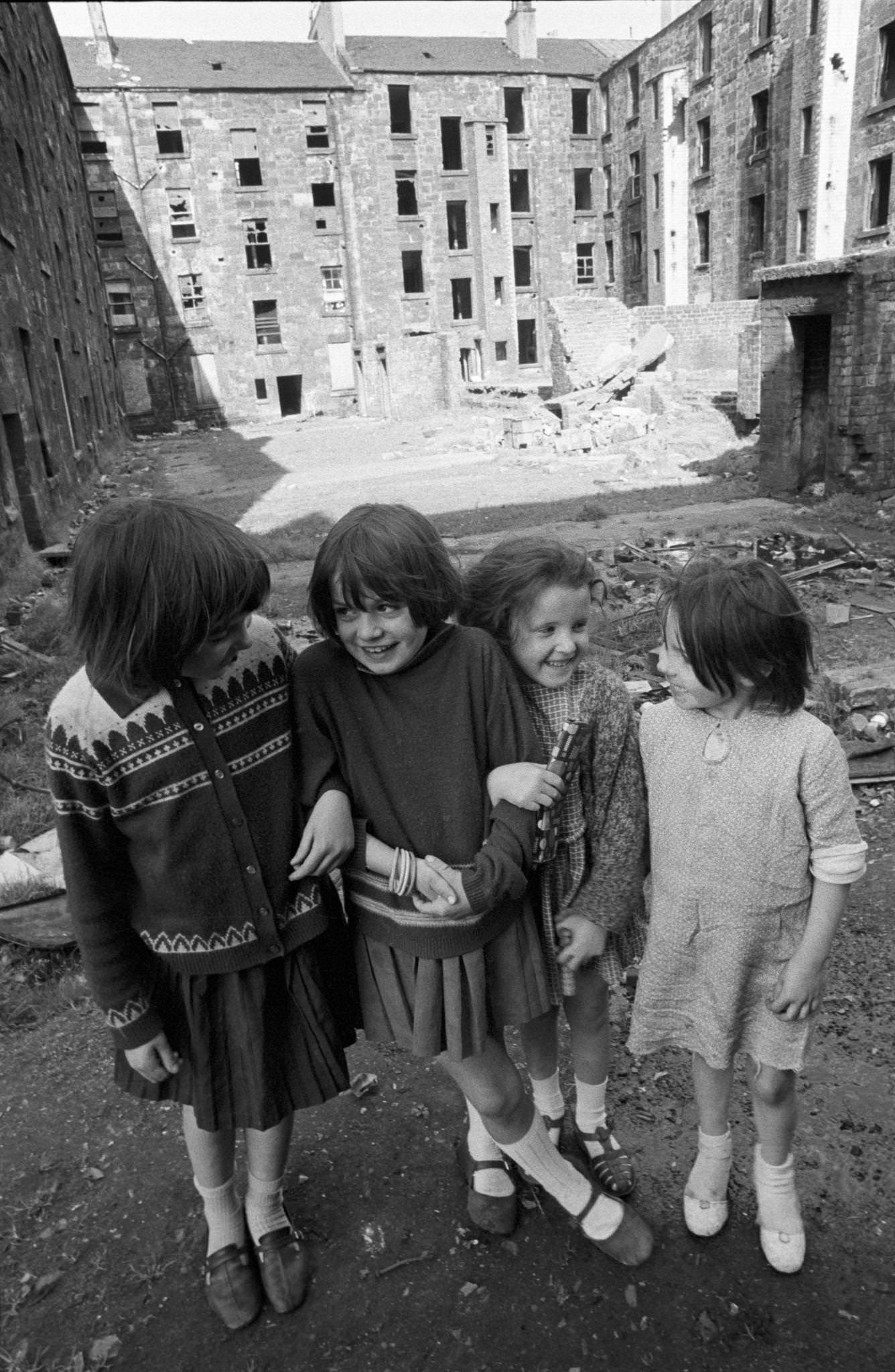 #57 Four little girls posing in front of slum housing in the notorious Gorbals district of Glasgow in 1969.