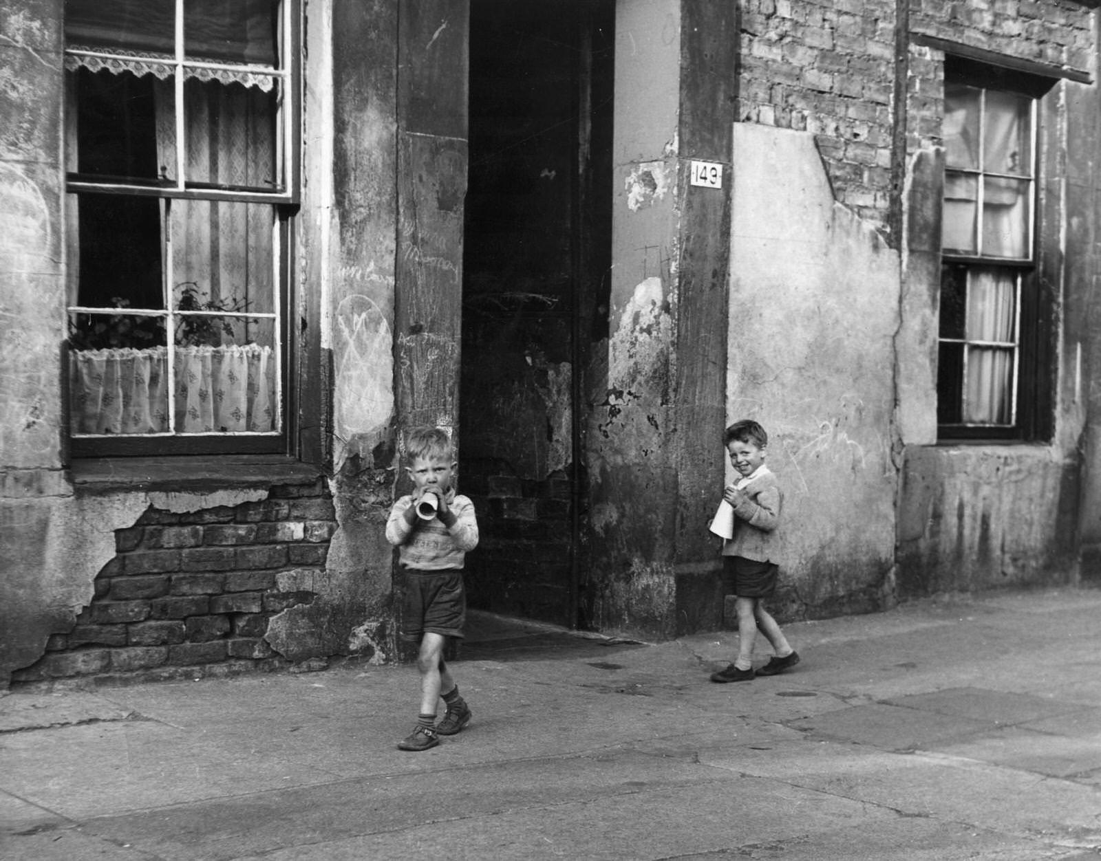 #79 Two young boys playing outside in the Gorbals district of Glasgow, which was described as having the worst slums in Europe, 1960