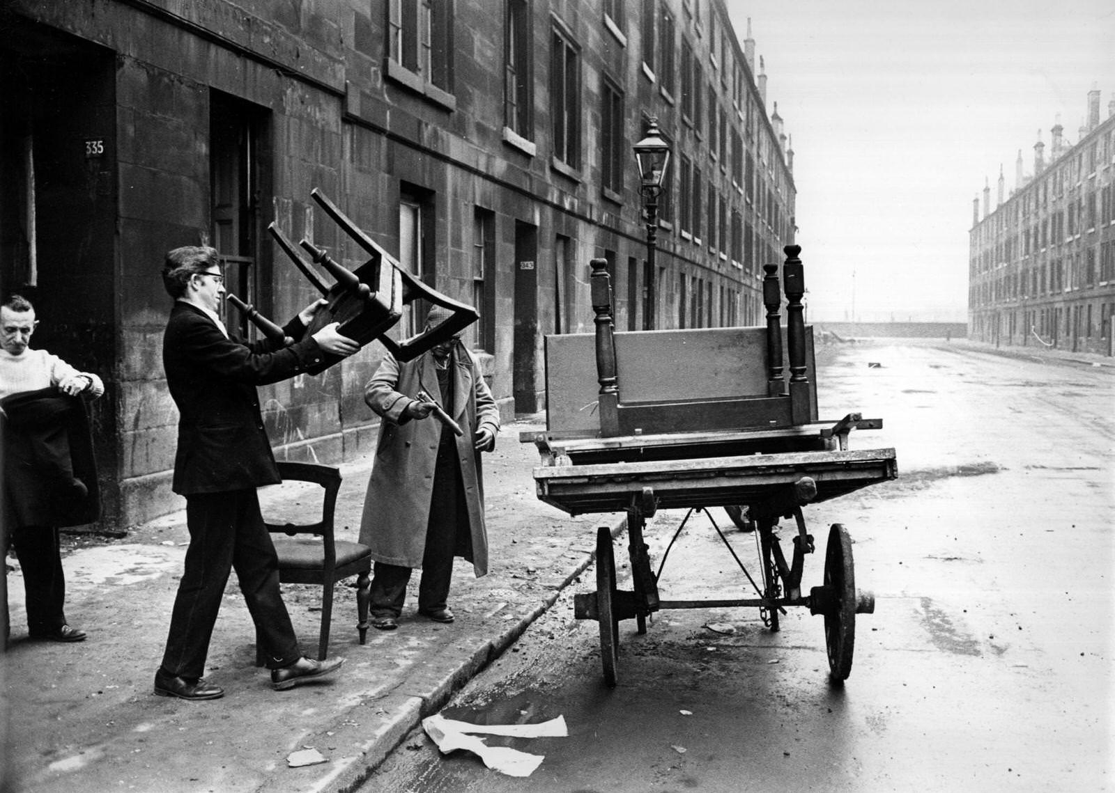 #86 A man piling furniture onto a cart in a street of soon-to-be-demolished tenements in the Gorbals area of Glasgow, 1960