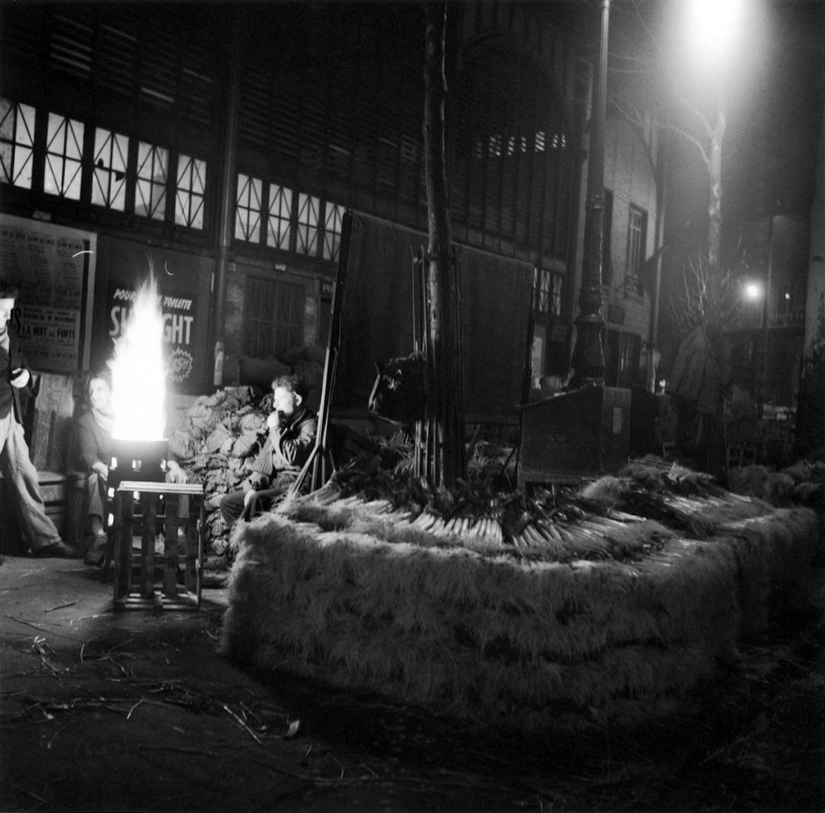 #11 Men in front of a brazier behind leeks at night in Les Halles, 1953