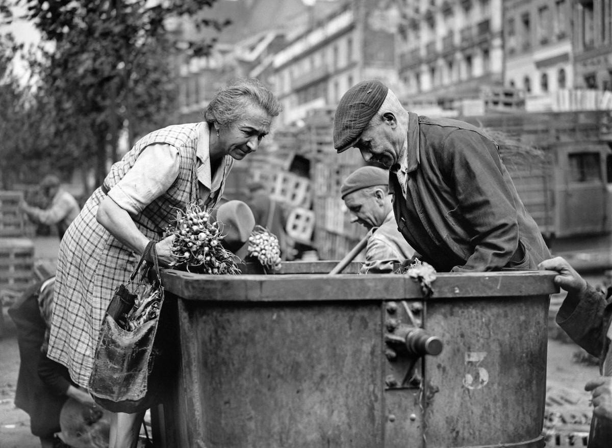 #126 People search a garbage can in August 1946, in the district of Les Halles in Paris, at the resumption of the activity in the Halles quarter