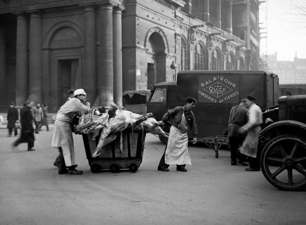 #129 Workers of a butcher’s shop carry meat in Les Halles district (central food market) in January 1946 in Paris during the meat strike.