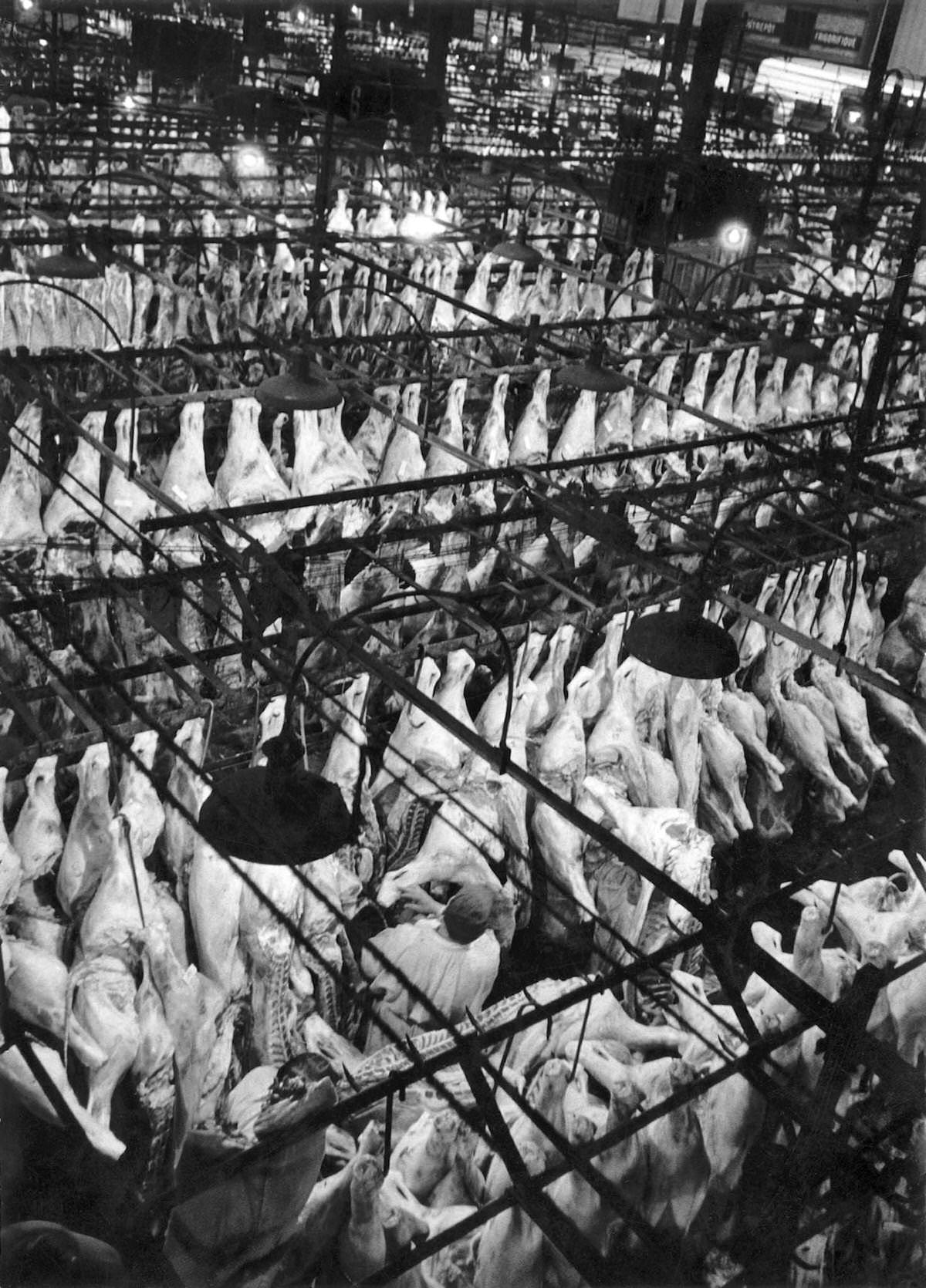 #43 The meat hall in Les Halles, which was historically the traditional central market of Paris, at seven in the morning, on June 3, 1955