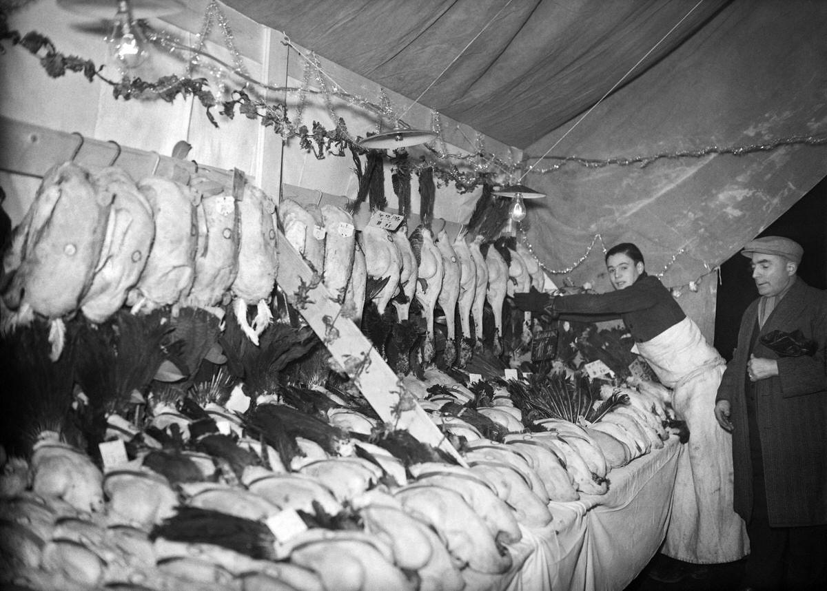 #19 A butcher sells his poultries at Les Halles district (central food market) in Paris on December 1938.