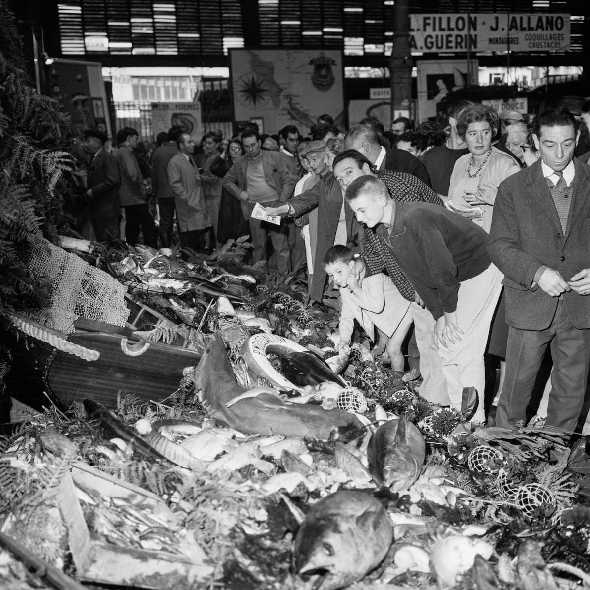 #98 The crowd admires the largest buffet in the world where fish of all kinds are artistically presented for the great fish fair, in Paris, 1967