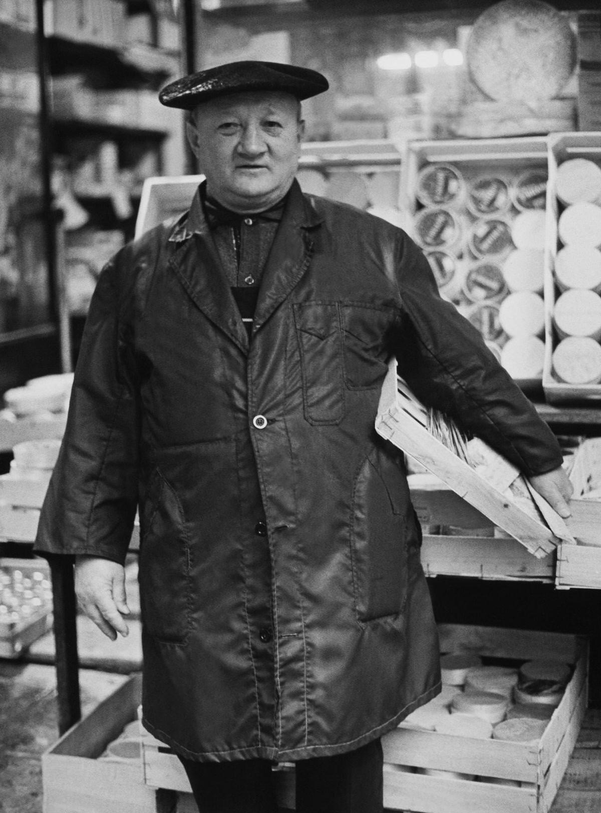 #114 A Traditional Cheesemarker in Front of his Stall, 1967