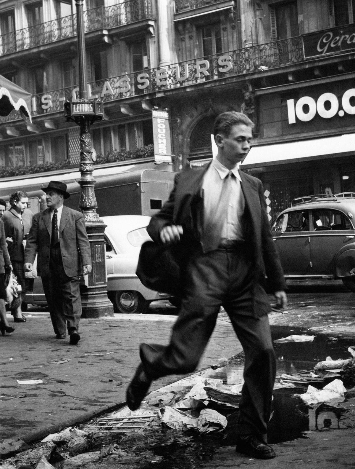 #8 A man jumping over a gutter in les Halles, 1953