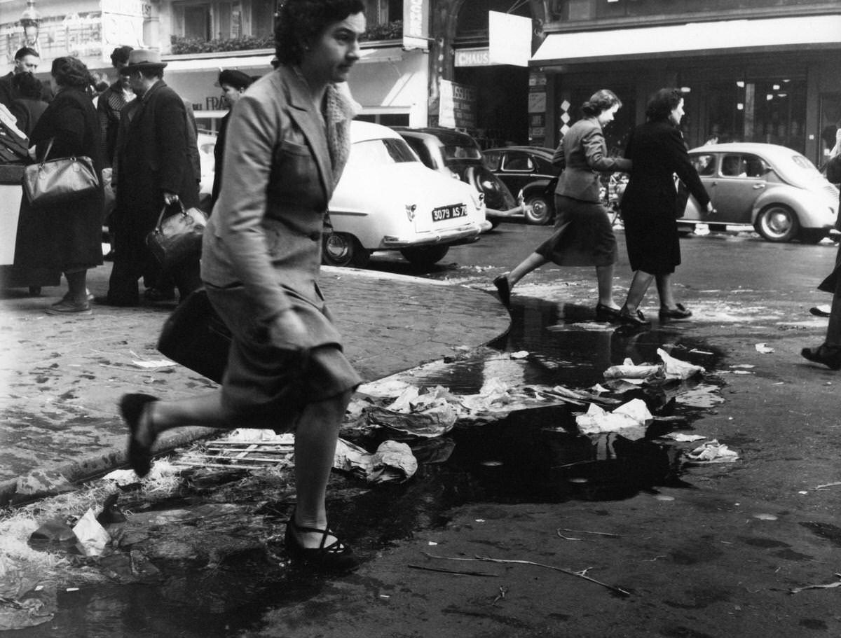 #9 A woman jumping over a gutter in les Halles, 1953