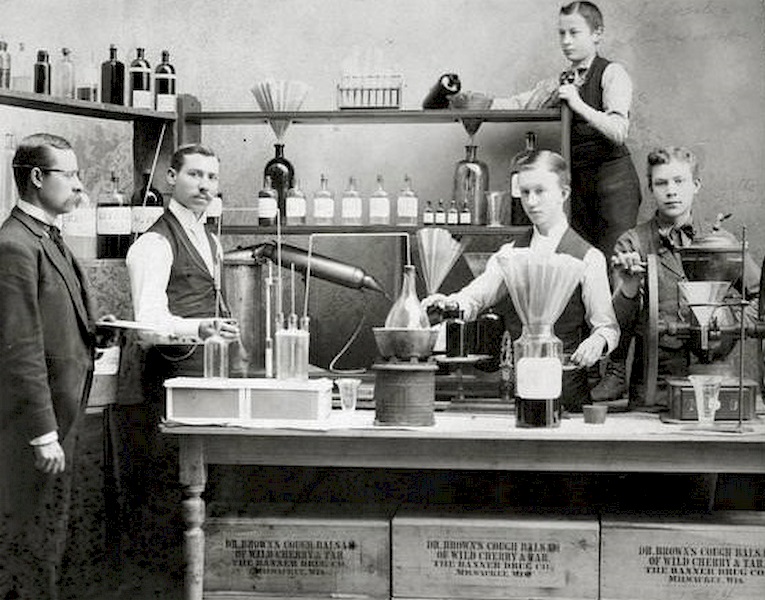 #74 Workers posing in front of pharmaceutical equipment to demonstrate the making of Dr. Brown’s Cough Balsam at Kienth Drugs and Medicines, 608 Mitchell Street, 1896