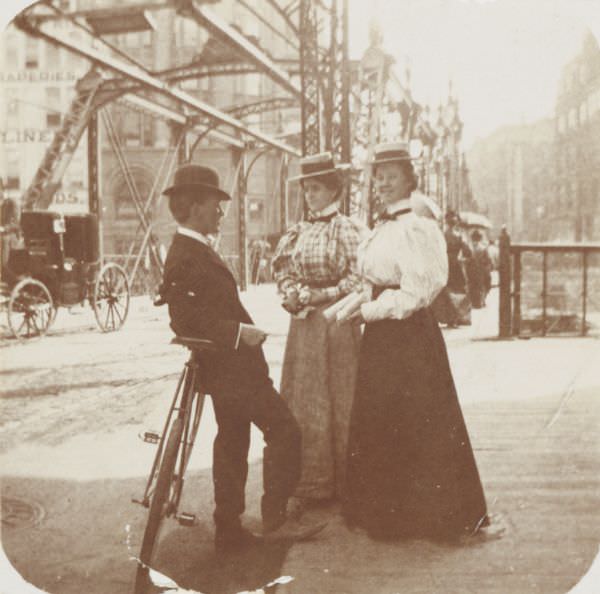 #77 A young man with two young women chatting on Wisconsin Street, 1896