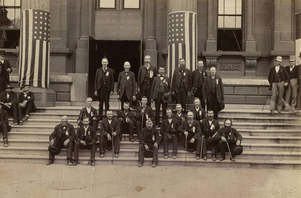 #64 Group portrait outdoors of the Veterans of Company I, 29th Wisconsin Volunteer Infantry at a Grand Army of the Republic reunion, Milwaukee, Wisconsin, 1887.