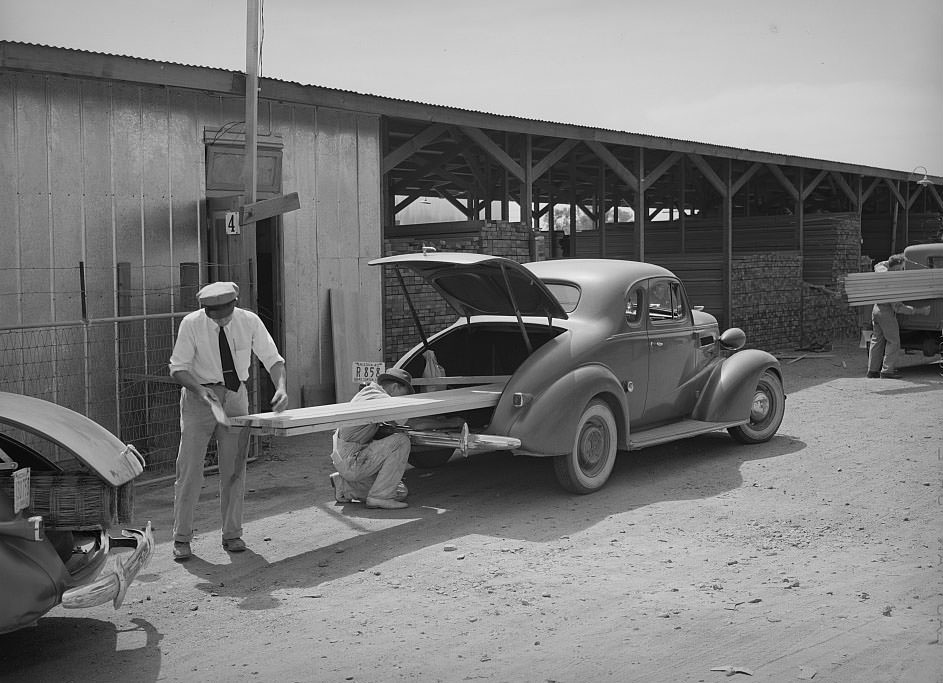 #120 Member of the United Producers and Consumers Cooperative loading lumber into his car, Phoenix, Arizona, 1940