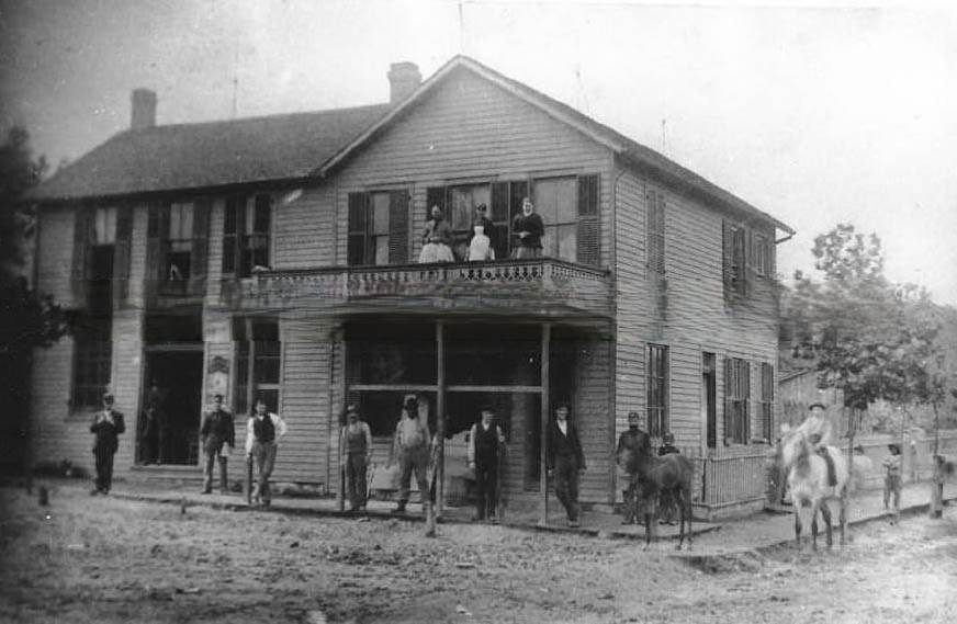 #149 A wood frame building wiht sign “Groceries & Provisions” and “Meat Market ” painted on the side, 1880.